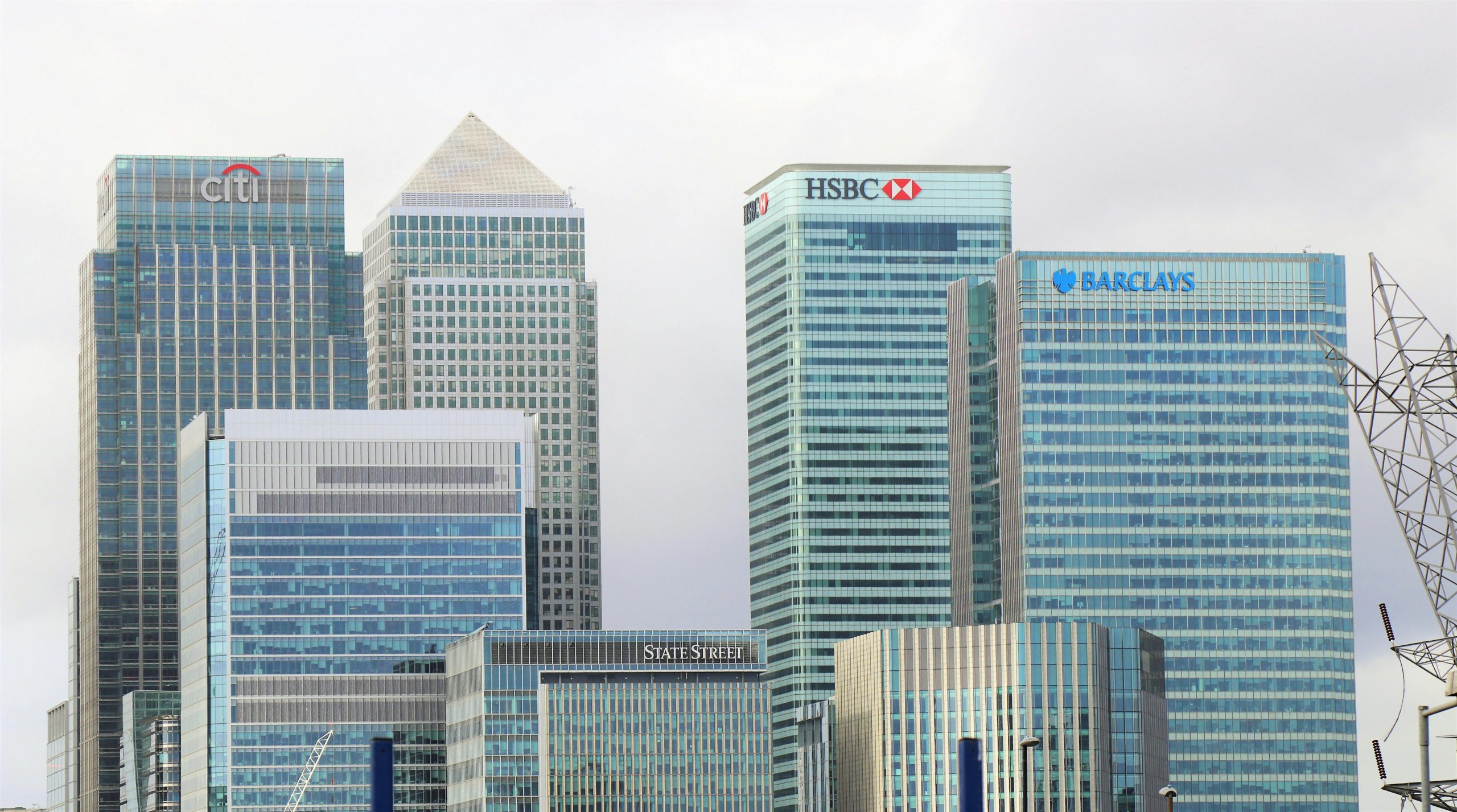 Investing in Legacy. Creating Growth. Modern skyline of Canary Wharf featuring iconic bank skyscrapers like HSBC and Barclays.